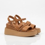 Vue de trois-quarts mettant en avant le design contemporain des sandales et le jeu sophistiqué de leurs lanières en cuir camel.
